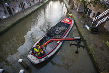 909457 Afbeelding van het opdreggen van fietswrakken uit de Oudegracht te Utrecht door de Gemeentelijke Reinigings- en ...